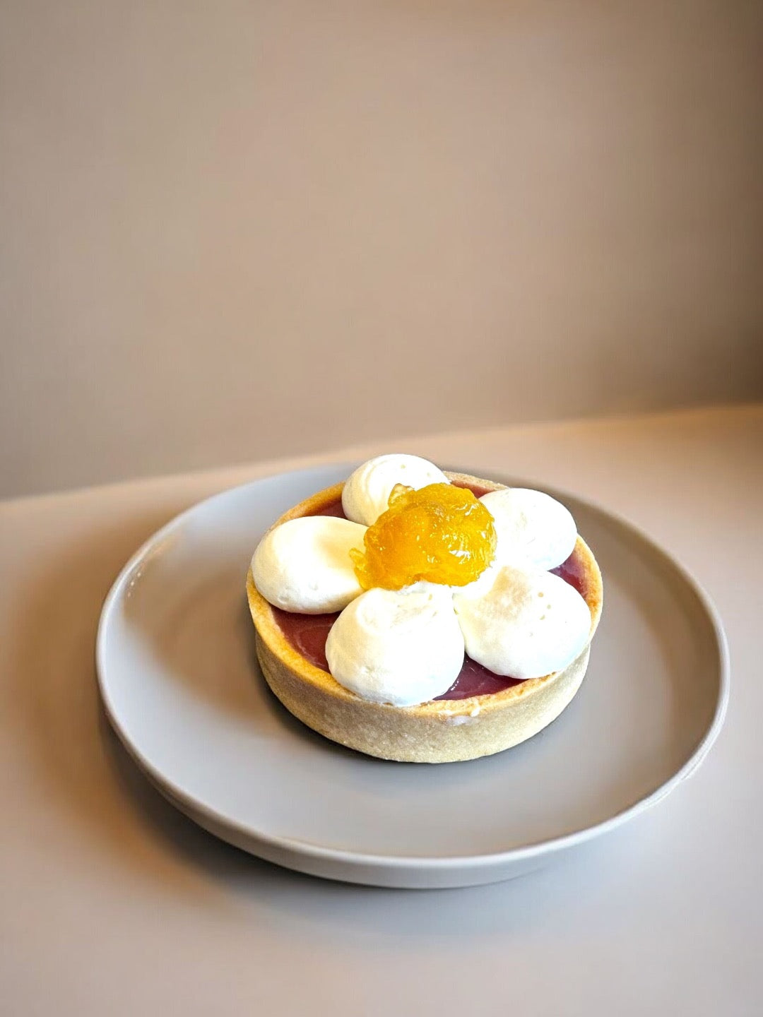 The tart is topped with an elegant floral design fashioned from mango mousse and mango puree.